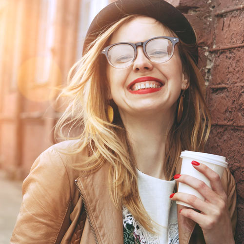 Happy, confident millennial woman drinking coffee