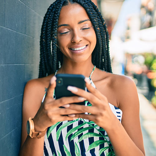 Smiling Millennial woman interacting with her cell phone
