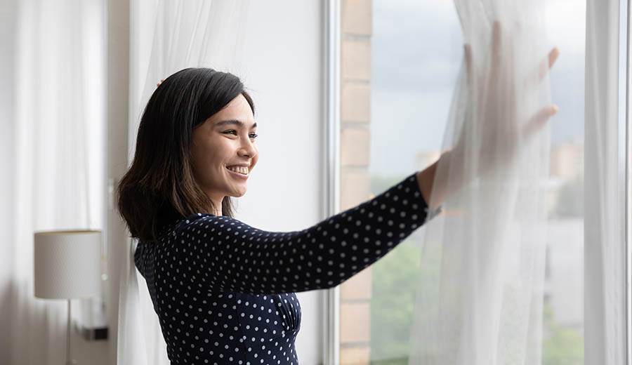 Woman pushing back the curtains